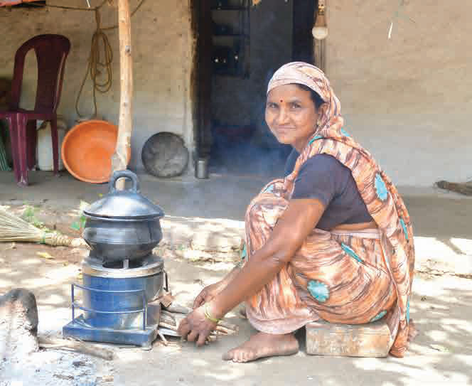 A woman cooking on an improved clean cookstove outside her home in rural Maharashtra.