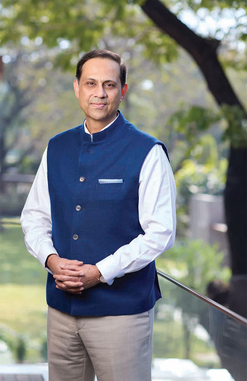 Sanjiv Bajaj, Chairman, standing in front of a bookshelf